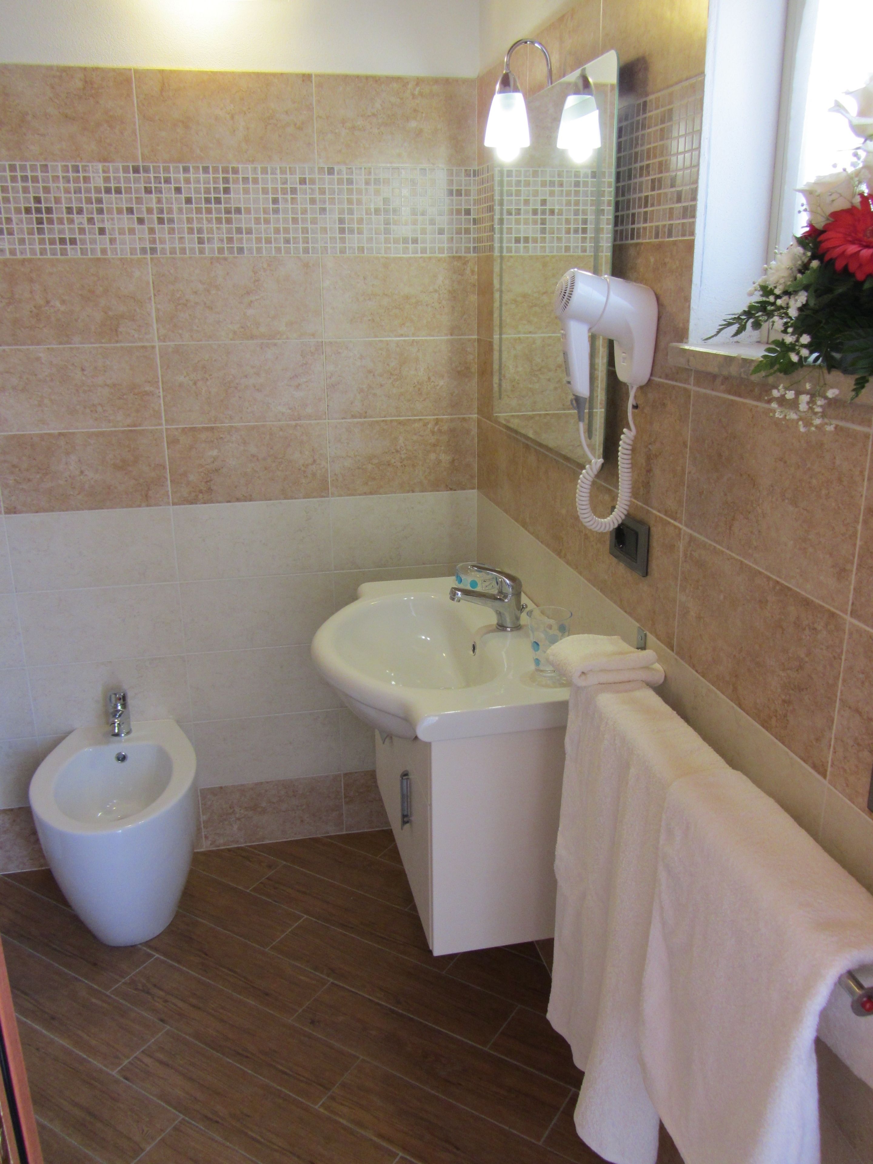 A bathroom with a bidet, a sink, and a towel rack.