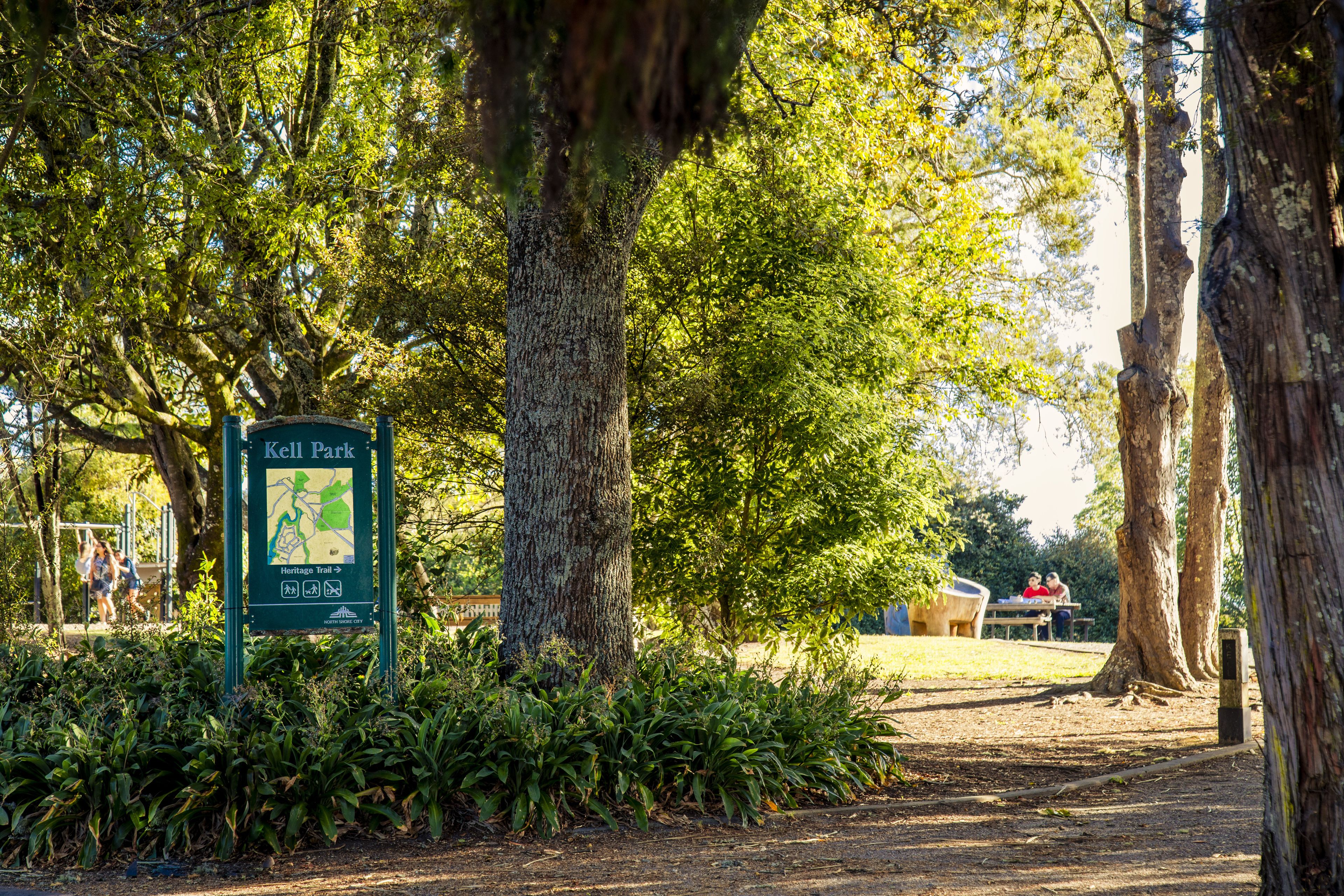 A park sign with a map and a Heritage Trail direction.