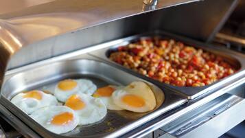 A buffet with cooked eggs and a dish of mixed vegetables.