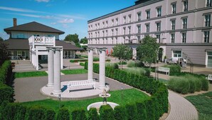 Une cour avec une fontaine, des colonnes blanches et un bâtiment doté de nombreuses fenêtres.