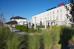 A hotel with a classical facade, large windows, and a well-maintained garden with tall grasses. - Hotel Lamberton (Ozarow Mazowiecki)
