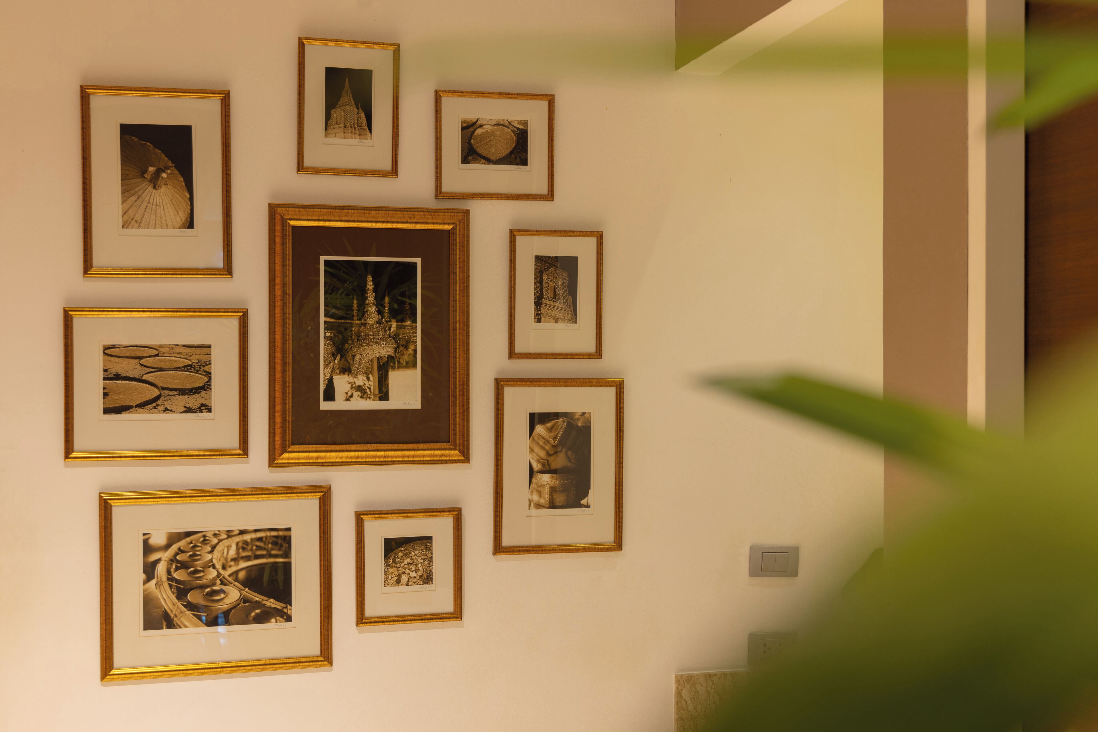 A wall with multiple framed photographs of architectural structures.