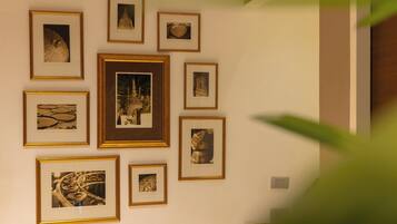 A wall with multiple framed photographs of architectural structures.