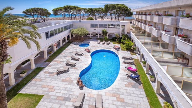 Un hôtel doté d’une piscine, d’un espace extérieur aménagé et offrant une vue sur la mer.