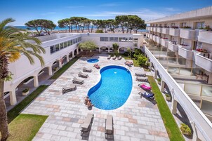 Una piscina al aire libre, tumbonas
