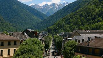A town with buildings lining a street, surrounded by mountains.
