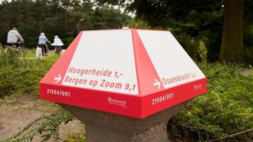 Un panneau de signalisation rouge et blanc indiquant les directions suivantes : Hoogerheide 1, Bergen op Zoom 9,1 et Ossendrecht 2,2.