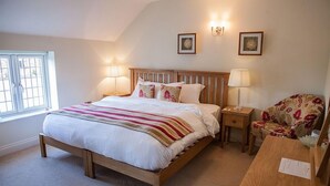 Une chambre à coucher avec un lit en bois, des lampes de chevet, une chaise et une fenêtre.