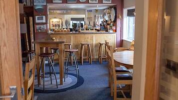 A kitchen with a central island, bar stools, and a dining table.