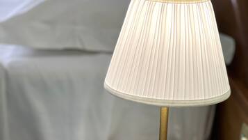 Un comodino con una lampada e un adattatore di corrente su una superficie color petrolio.