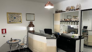Een compacte keuken met een eethoekje, een decoratieve lantaarn en een laptop op het aanrecht.