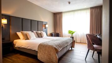 Une chambre d’hôtel moderne avec un grand lit, un bureau et une chaise.