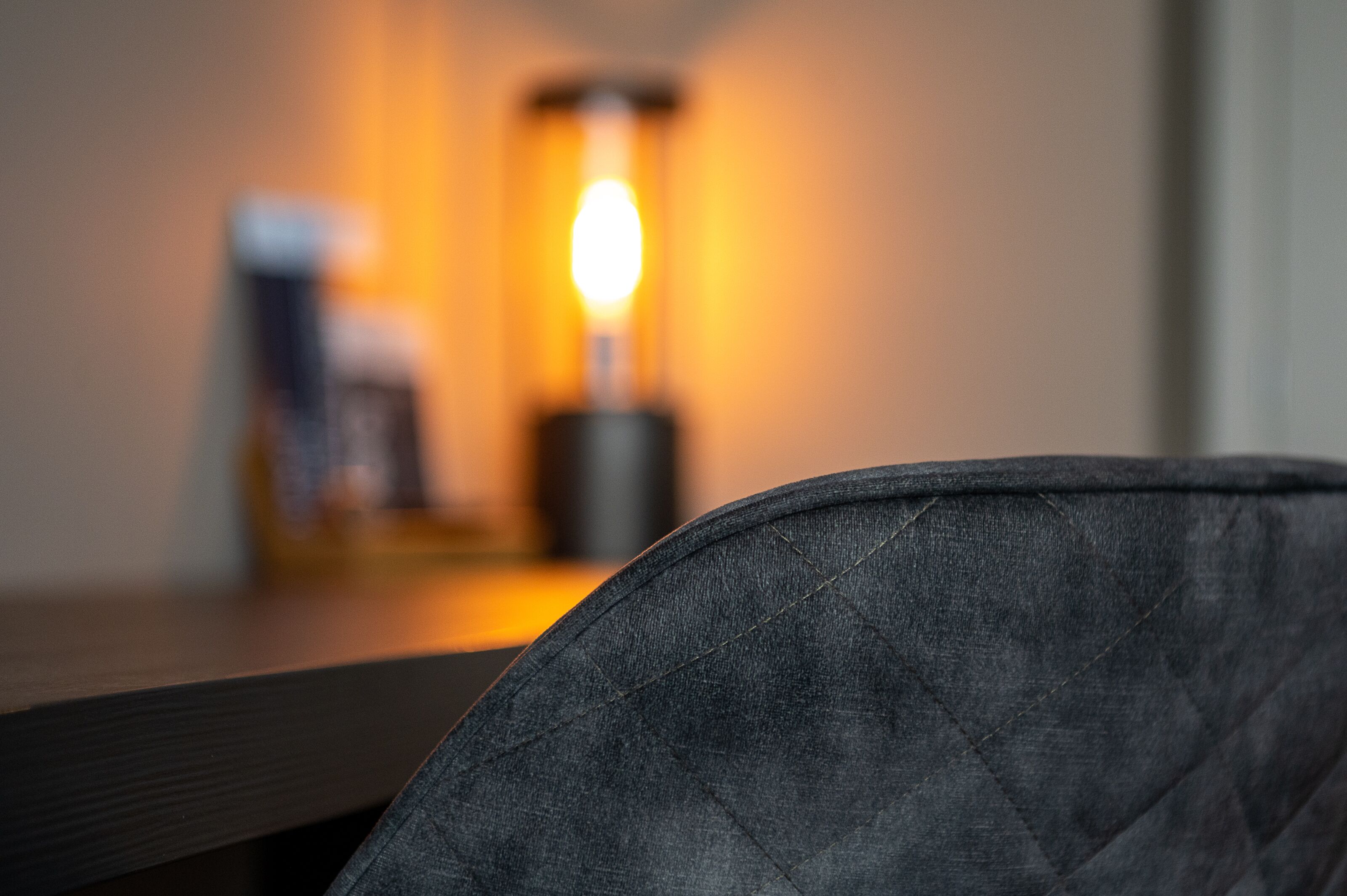 Primer plano de un sillón oscuro de tela con un diseño texturizado, probablemente de denim o material similar.