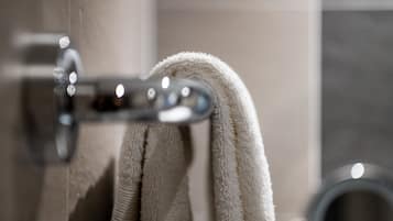A bathroom with a towel rack holding a white towel.