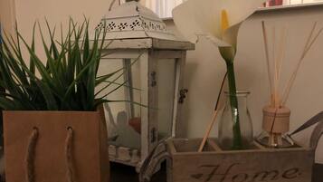 A wooden box with the word "Home" on it, a white lantern, a calla lily, and a potted plant.