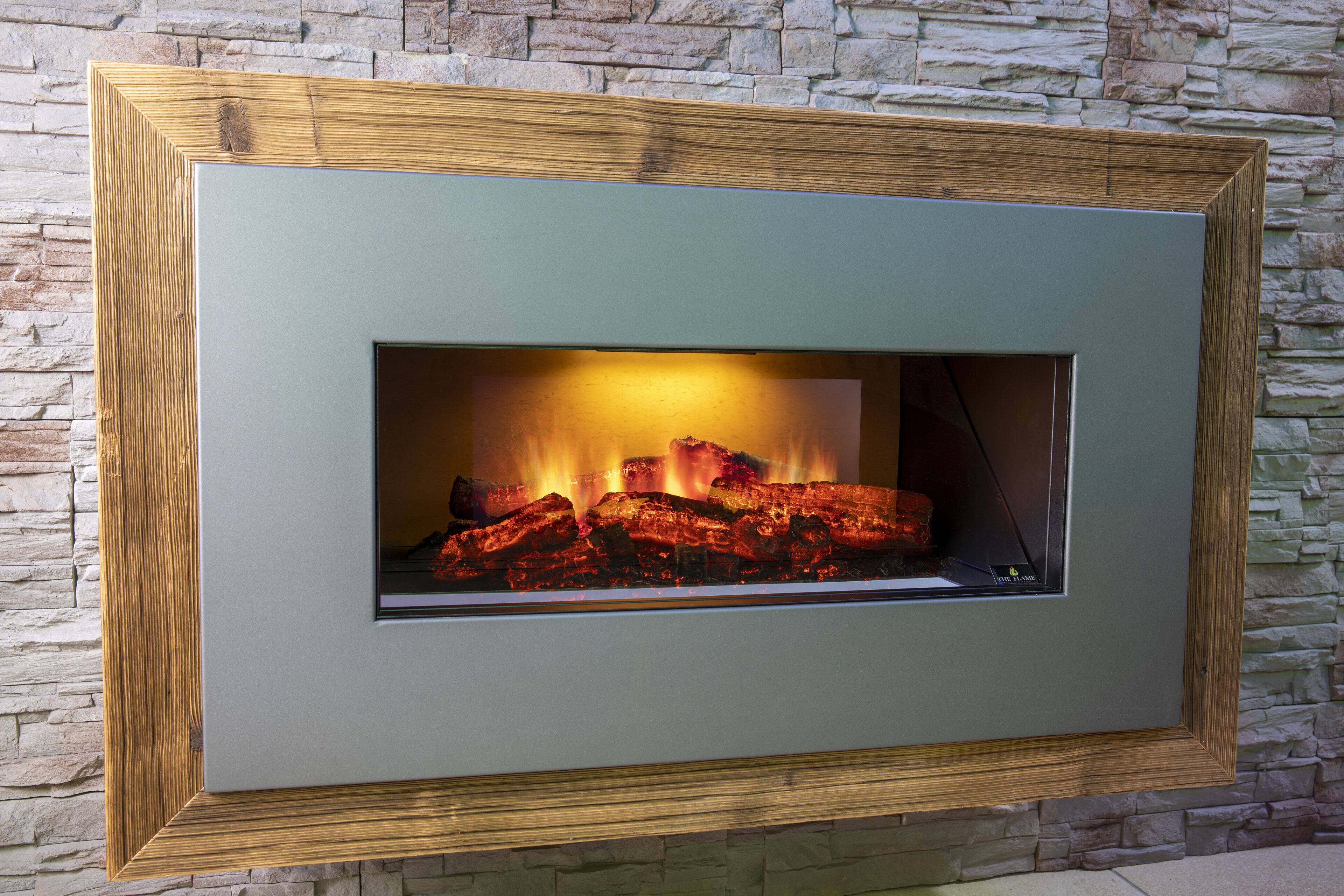 A fireplace with a stone wall backdrop.