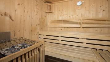 A sauna with wooden benches, a ventilation system, and a clock on the wall.