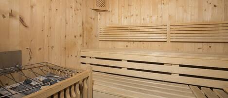 A sauna with wooden benches, a ventilation system, and a clock on the wall.
