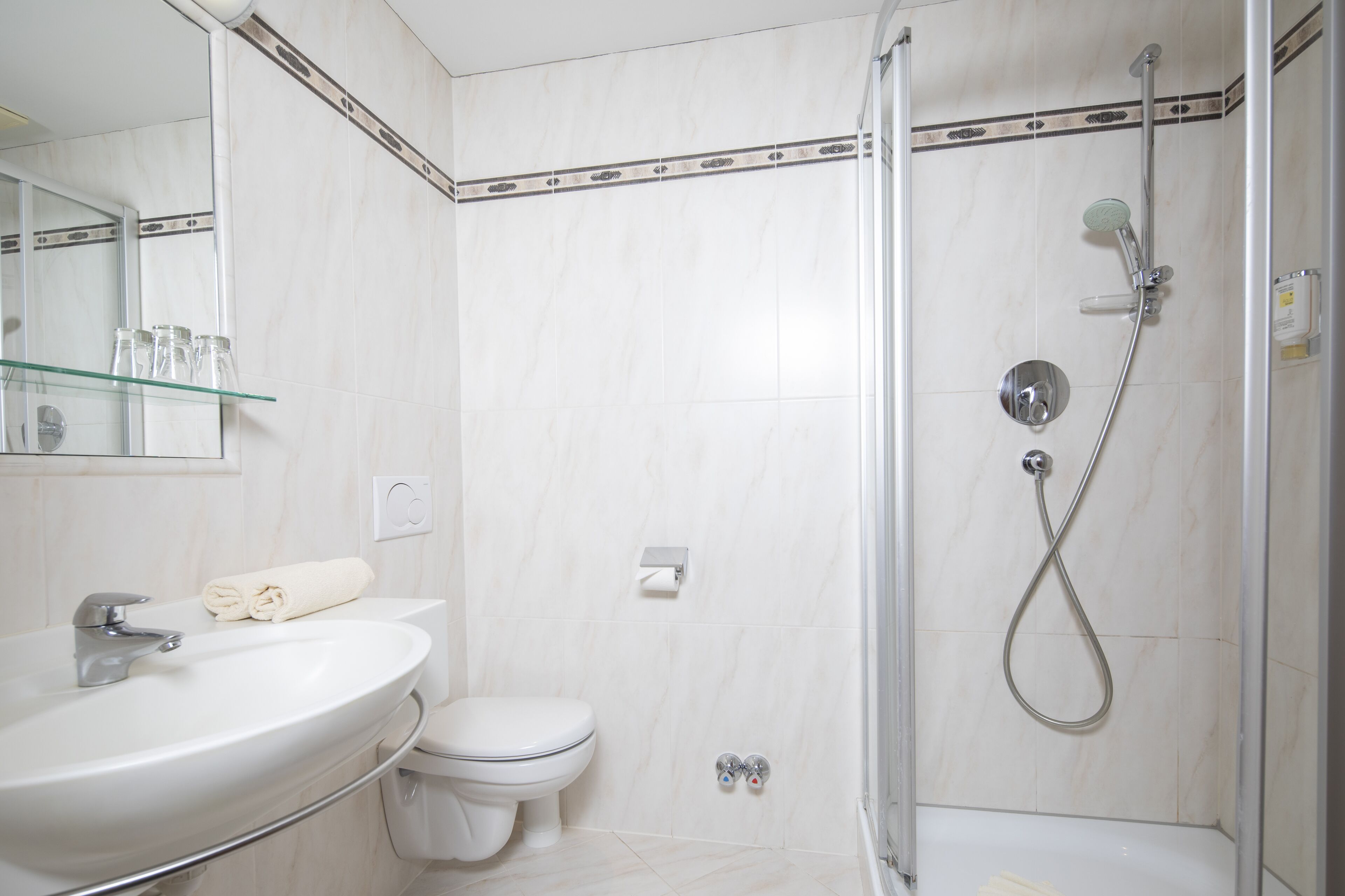 Une salle de bain moderne avec un lavabo, des toilettes et une douche.