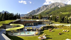 A resort with a pool, lounge chairs, and a mountainous backdrop. - Sottovento Luxury Hospitality (Bormio)