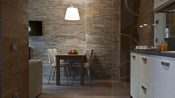 Una cocina moderna con salpicadero de piedra, armarios de madera y un comedor con mesa y sillas.