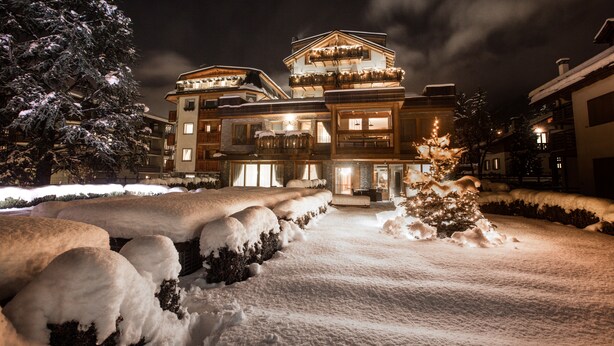 A large, multi-story hotel with a snow-covered driveway and exterior. - Sottovento Luxury Hospitality (Bormio)