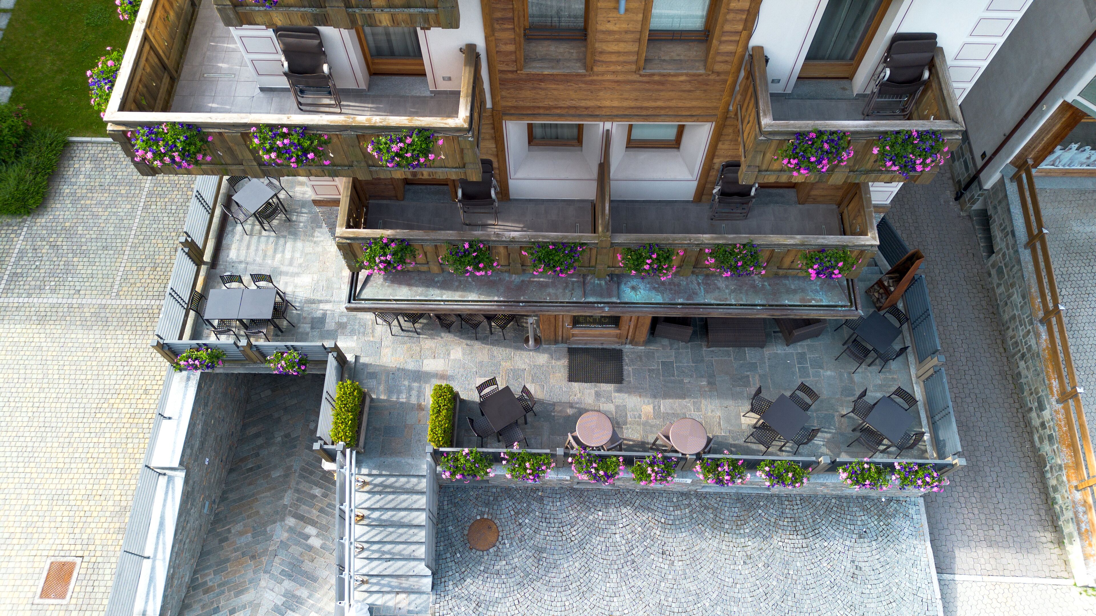 Une terrasse extérieure à plusieurs niveaux, dotée d’espaces pour s’asseoir et de jardinières.