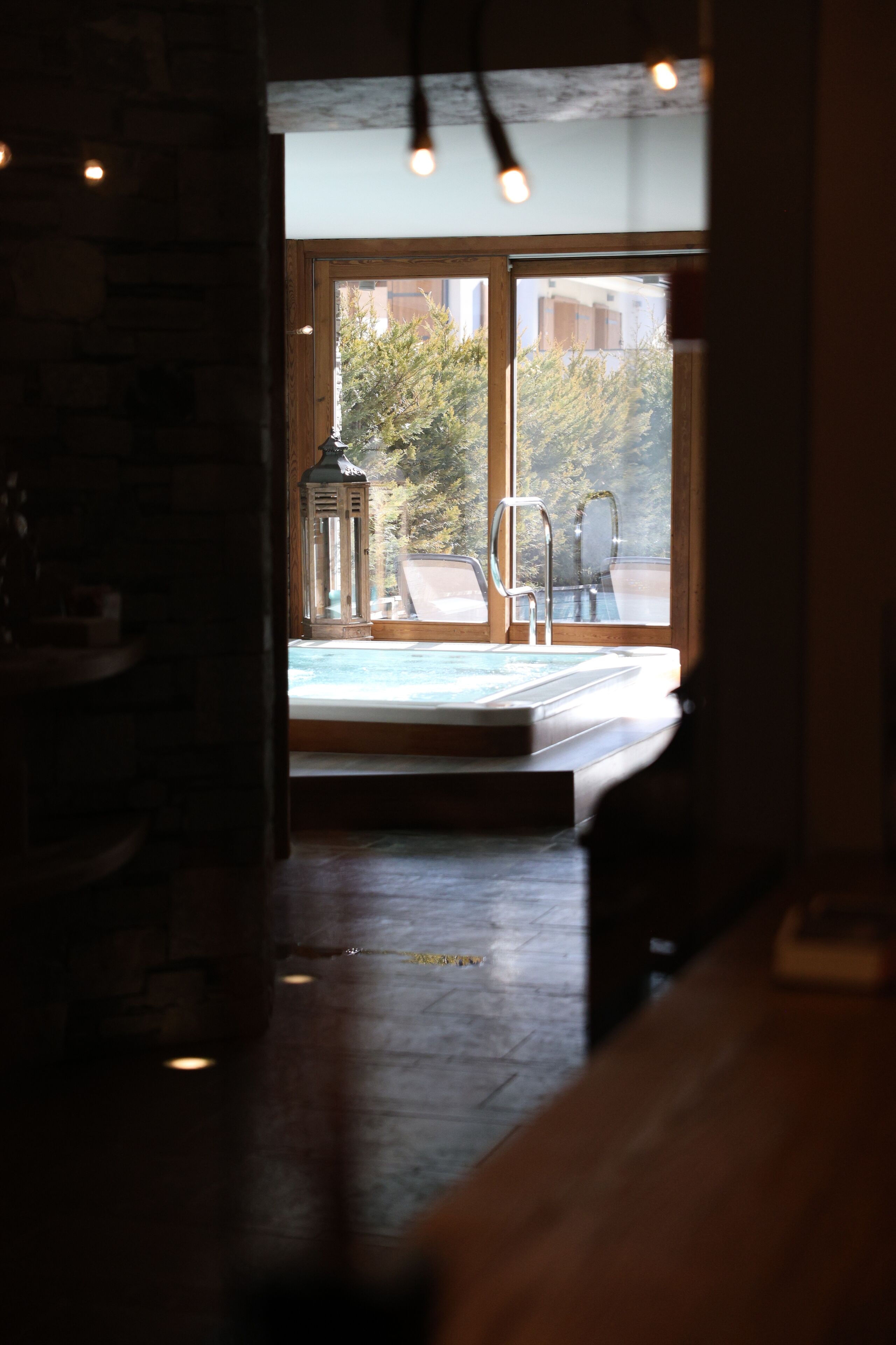 Habitación con vista a una piscina y mobiliario exterior.