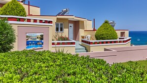 A modern building with a pool, solar panels, and a view of the sea. - Everest Apartments (Hersonissos)
