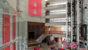 A spacious lobby with multiple seating areas, a staircase, and a decorative red wall. - The Creekside Hotel Dubai an Accor Hotel (Dubai)
