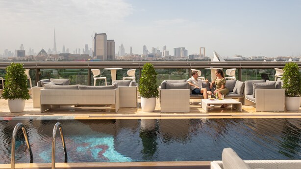 A rooftop pool area with outdoor seating and a city skyline view. - The Creekside Hotel Dubai an Accor Hotel (Dubai)