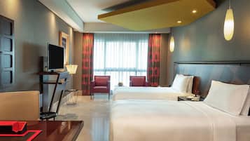 A hotel room with two beds, a TV, a desk, and a chair.