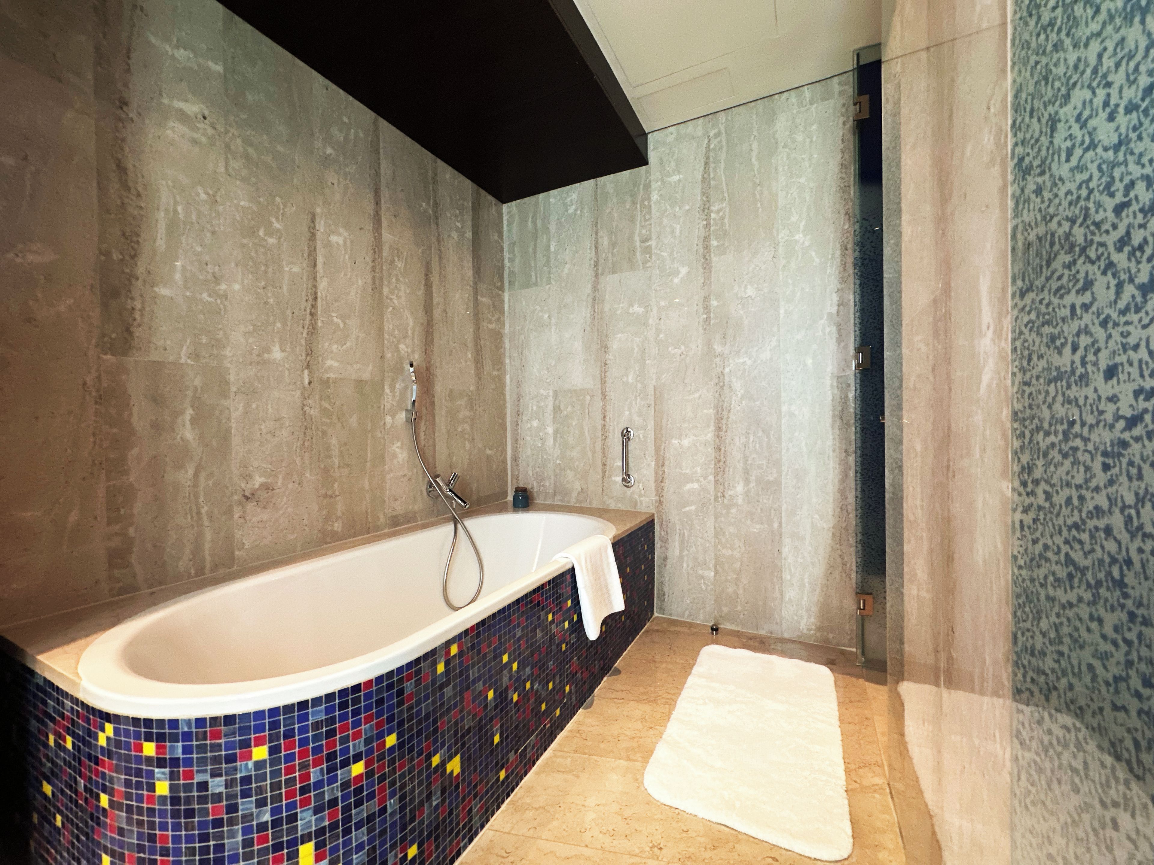 A modern bathroom with a freestanding bathtub, a shower area, and a tiled floor.