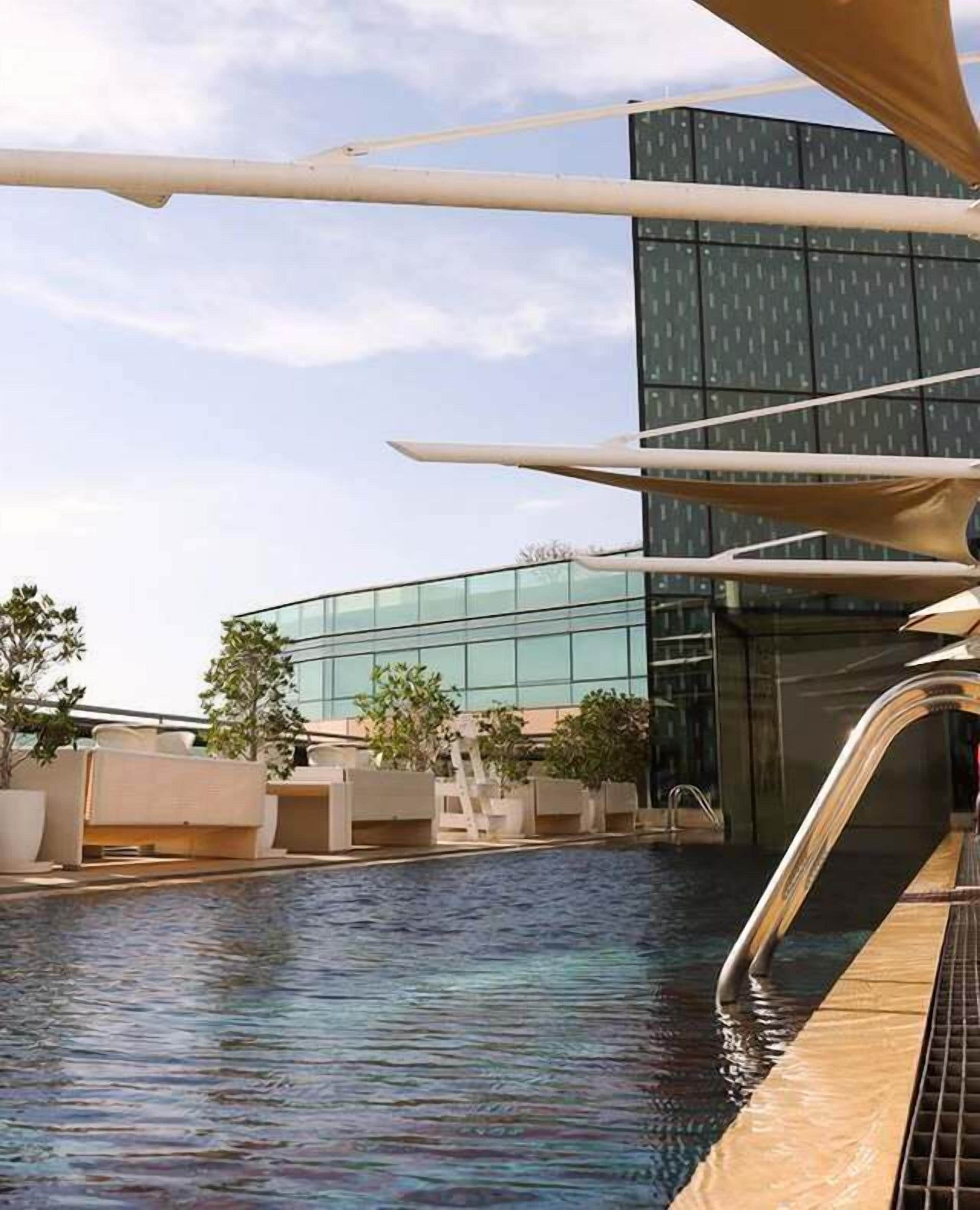 Una piscina con un edificio moderno al fondo.
