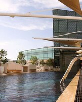 Una piscina con un edificio moderno al fondo.