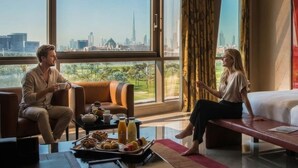 A modern hotel room with large windows, a dining table with breakfast, and a city view. - The Creekside Hotel Dubai an Accor Hotel (Dubai)