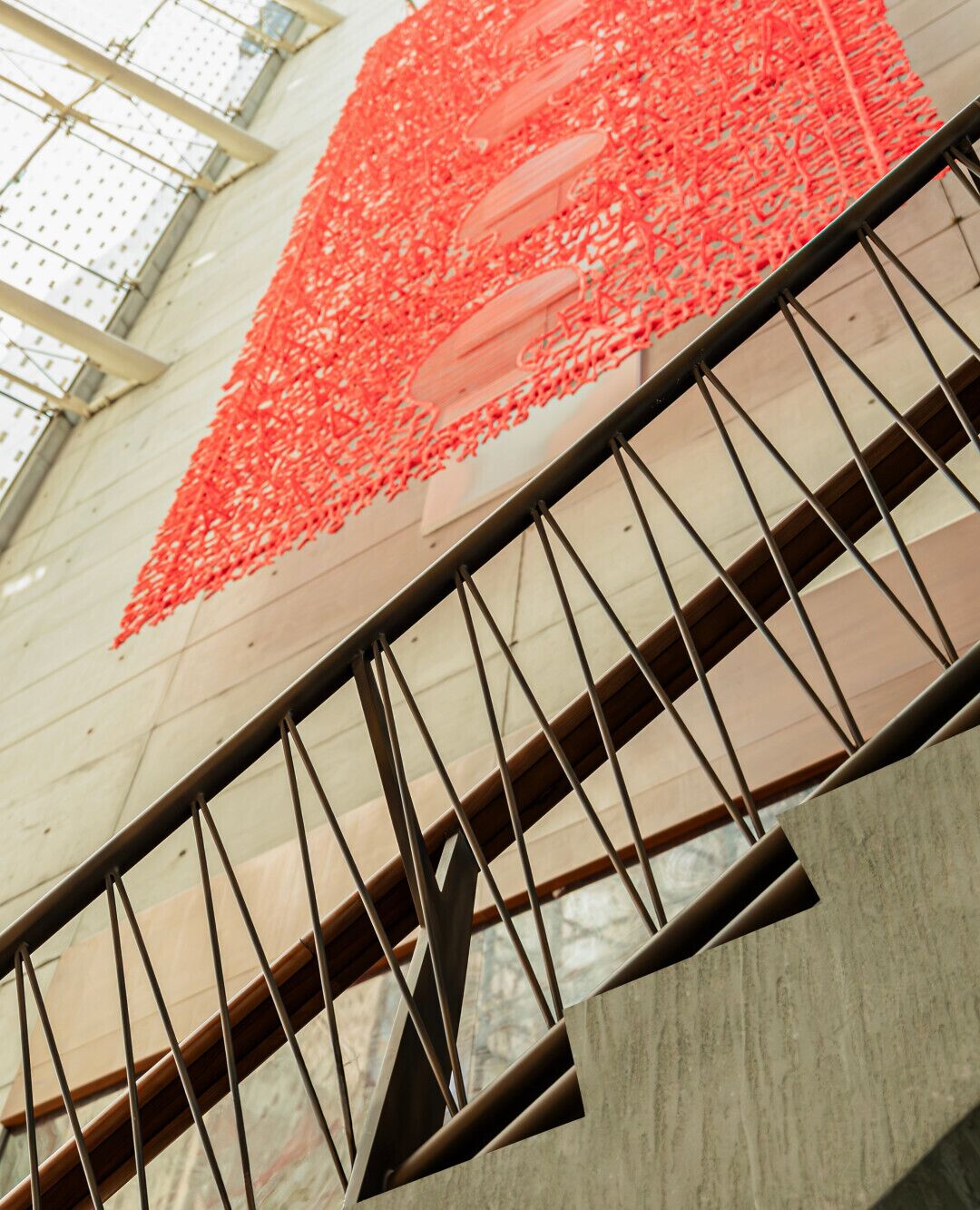 A staircase with metal railings and a red netted structure above.