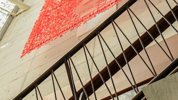 Una escalera con barandillas metálicas y una estructura de red roja en la parte superior.