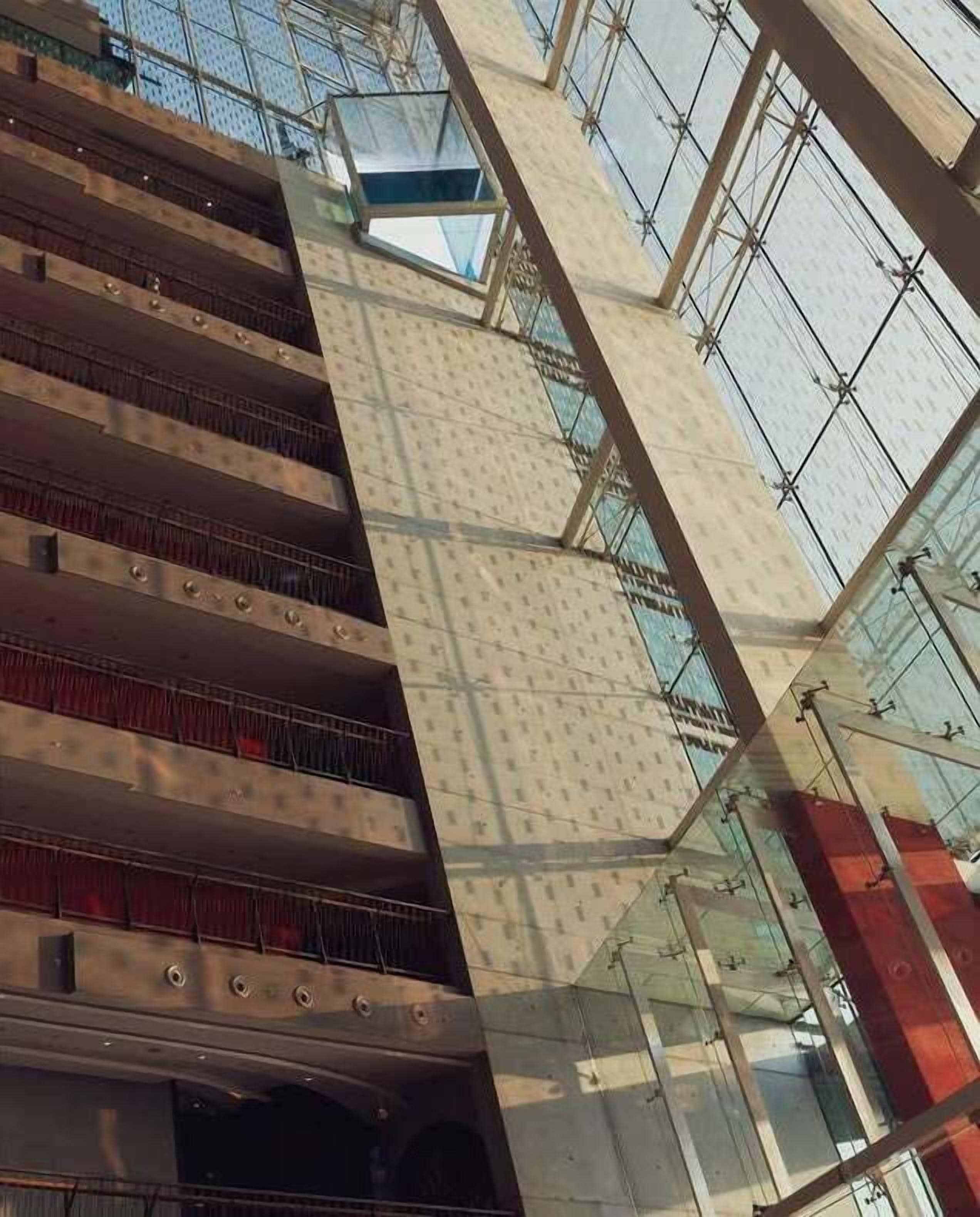 Un atrium de diversos nivells amb baranes de vidre i un disseny arquitectònic modern.