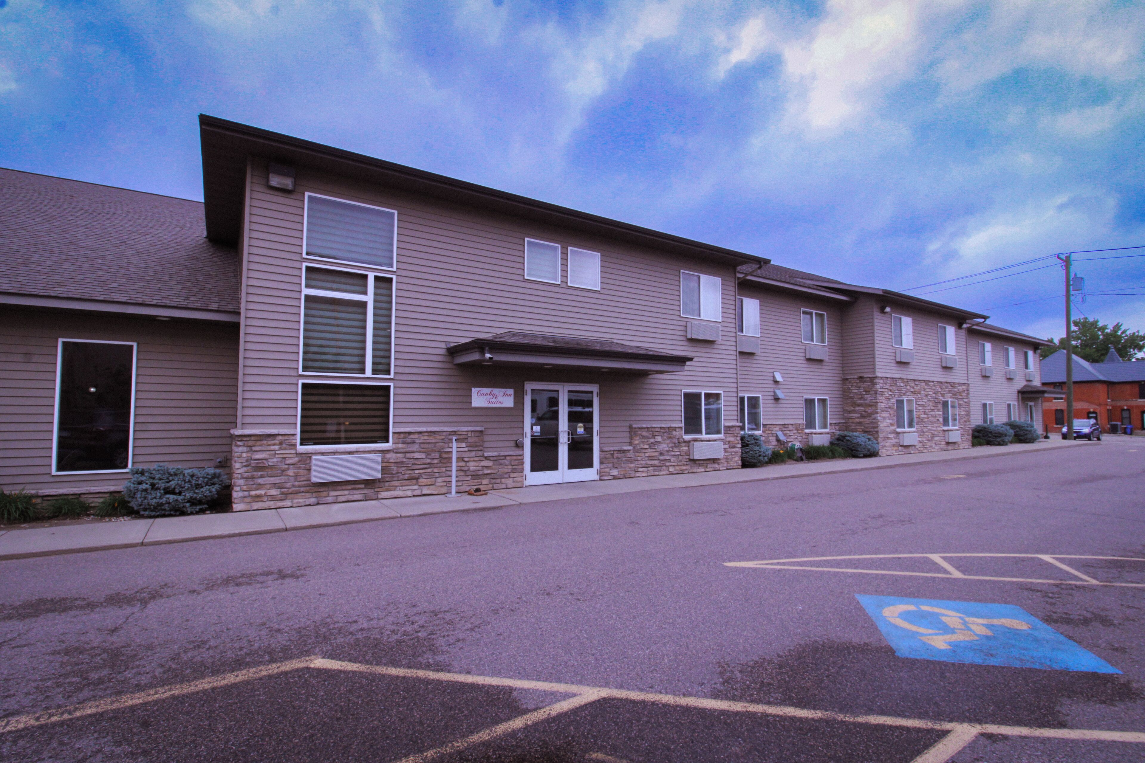A multi-story building with a parking lot in front.