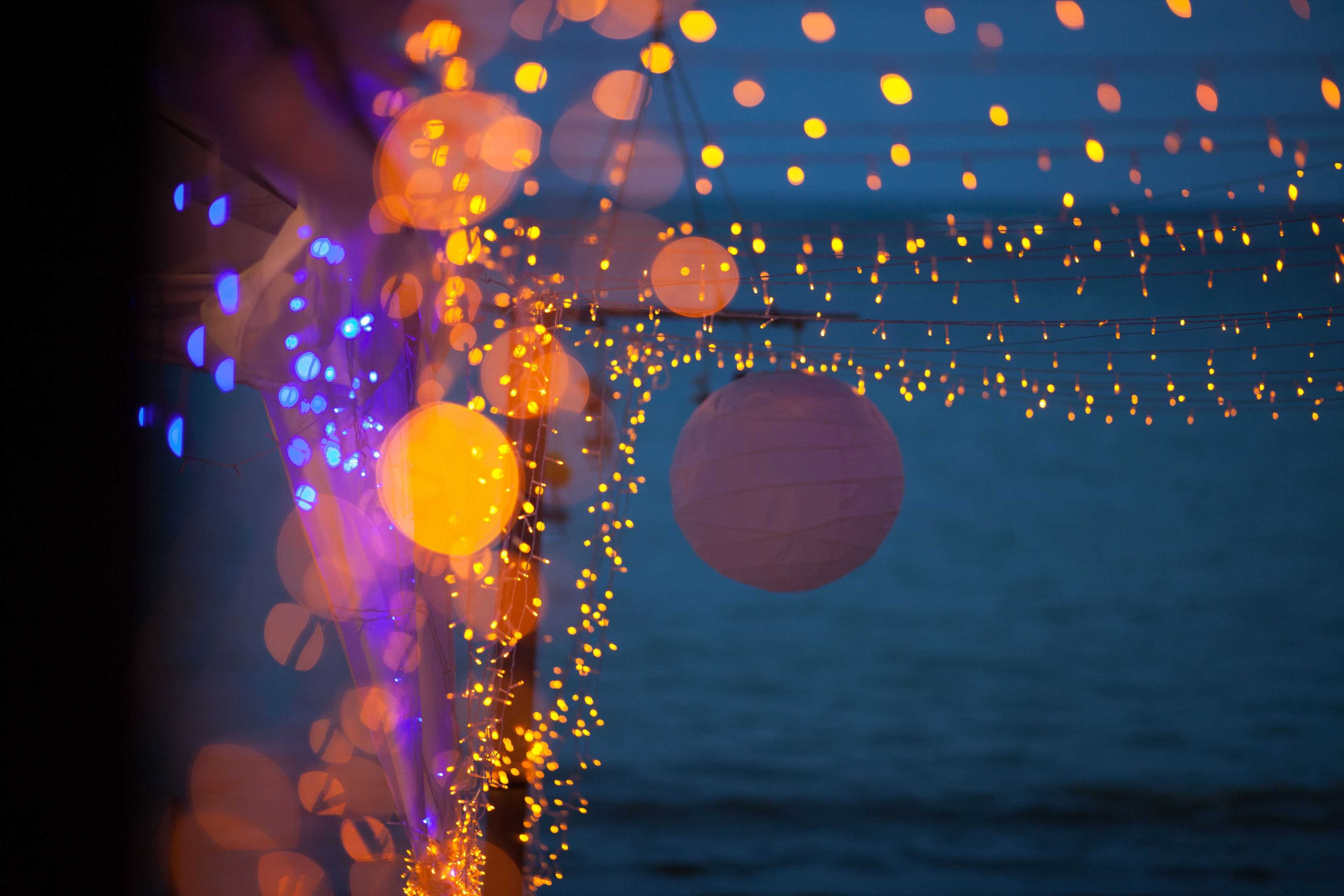 A string of lights and paper lanterns against a dark background.