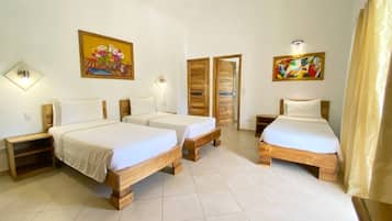 A room with three wooden beds, white bedding, and two wall-mounted light fixtures.