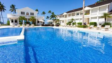 Een buitenzwembad, parasols voor strand/zwembad
