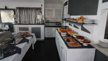 A buffet setup with various food items and a coffee station.