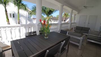 An outdoor patio with a dining table, chairs, and a sofa.