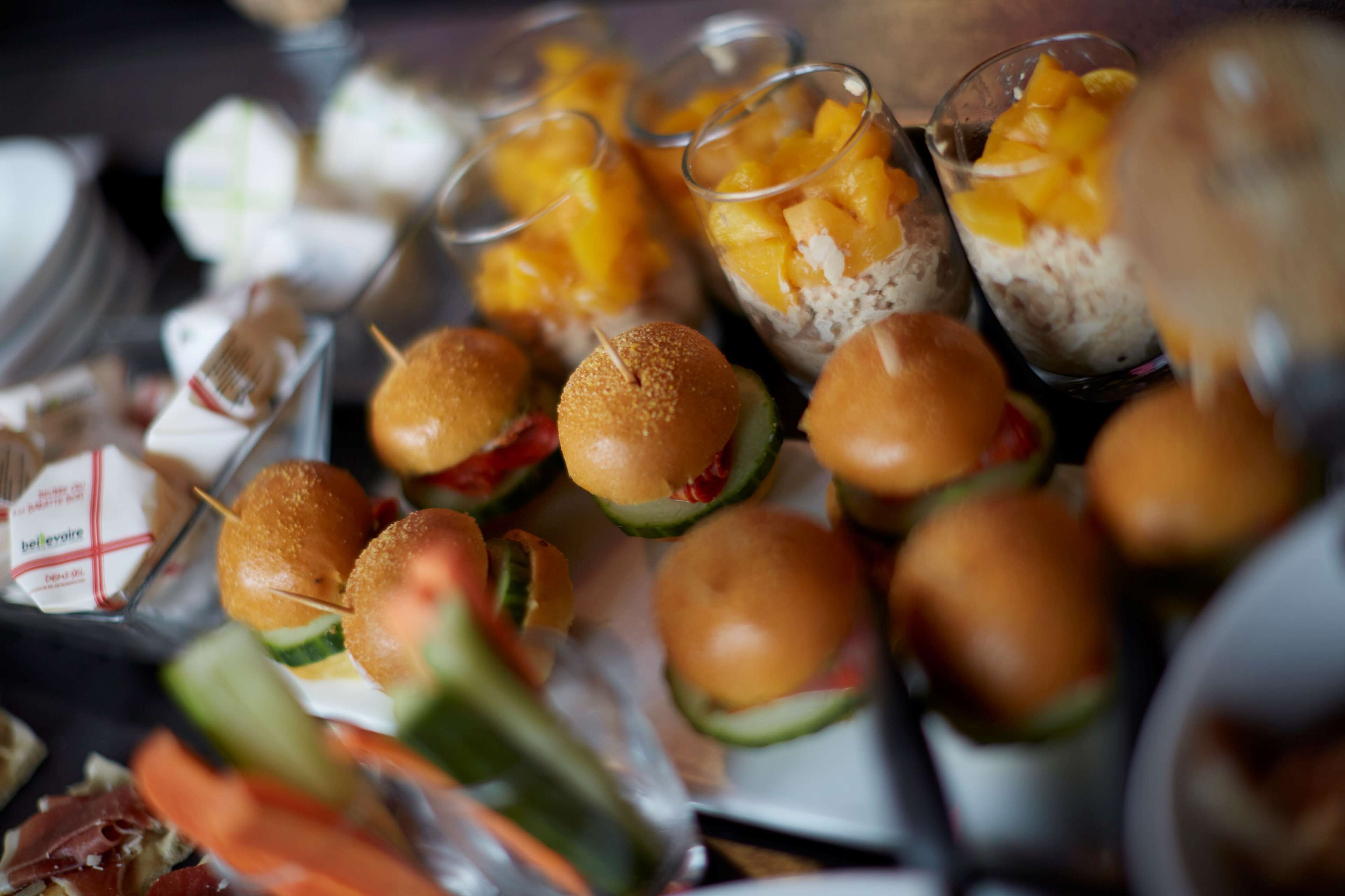 Un buffet con diverse pietanze, tra cui panini, frutta e verdura.