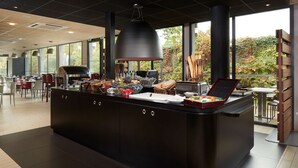 Un área de cocina moderna con una isla grande, una parrilla y vistas al exterior.