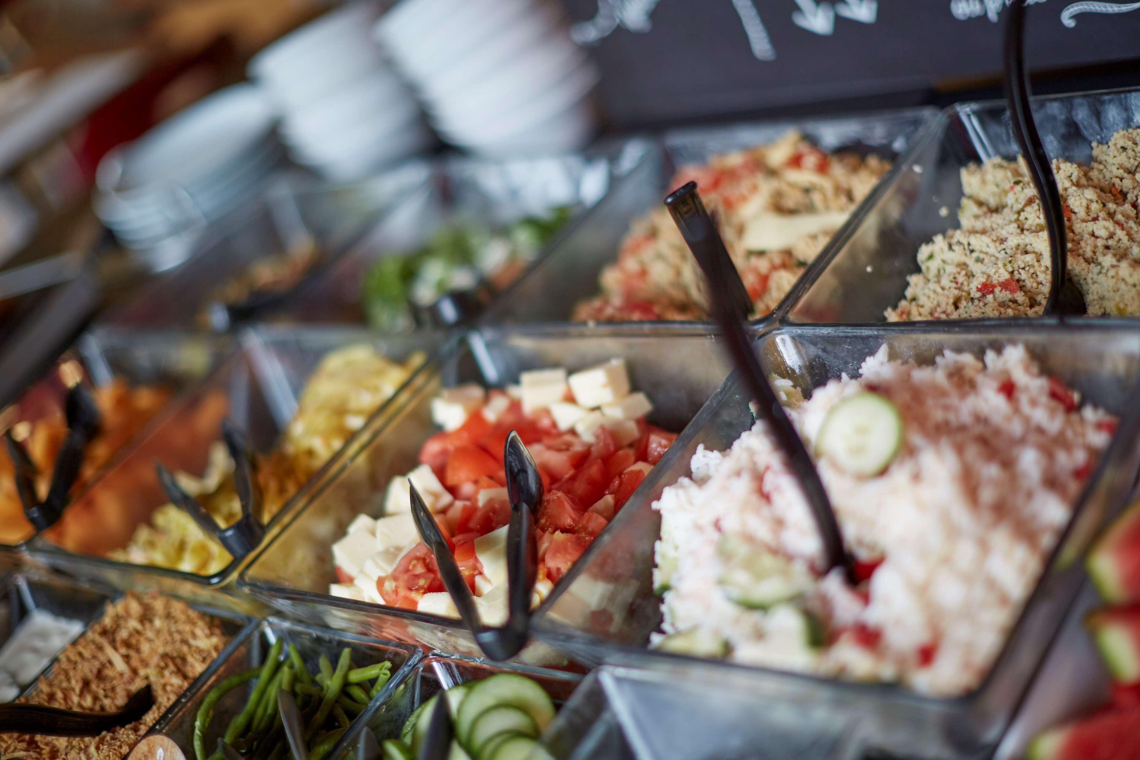 Ein reichhaltiges Buffet mit verschiedenen Speisen, darunter Salate, Fleisch und Gemüse.