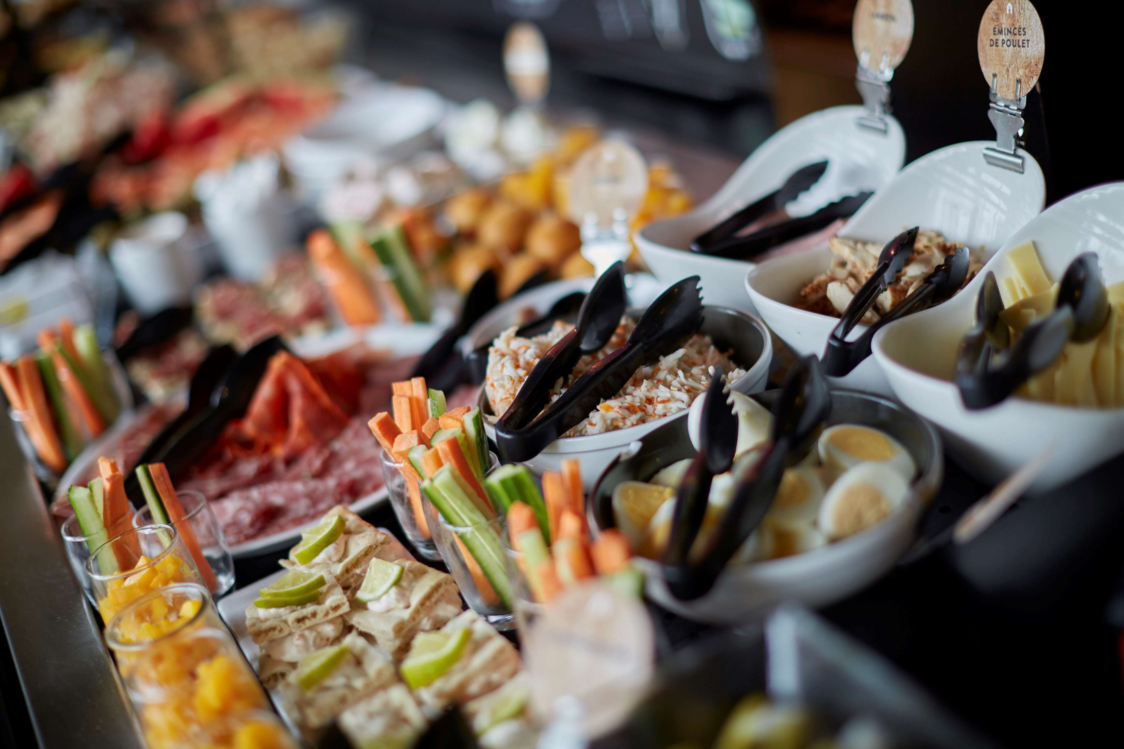 A buffet with various food items including meats, cheeses, and vegetables.