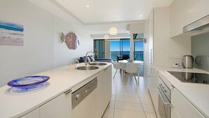 Une cuisine moderne dotée d’un îlot central, d’un coin repas offrant une vue agréable et d’un balcon avec vue.